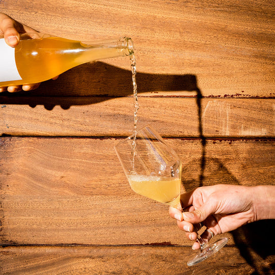 A glass of wine is poured with a wooden background